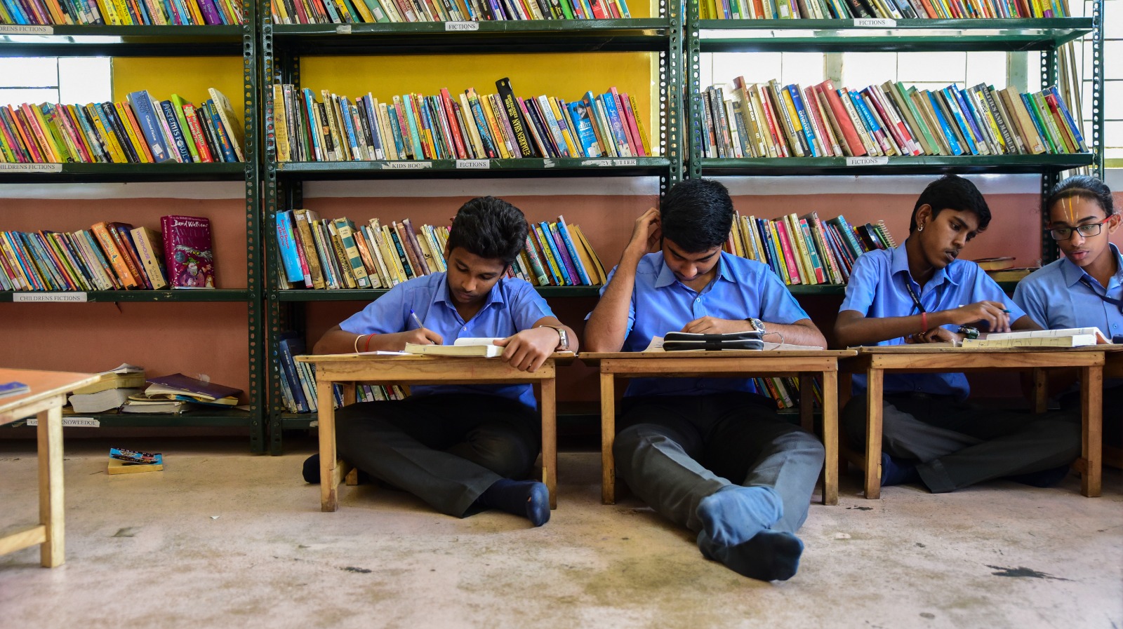 Students reading leisurely on the library floor